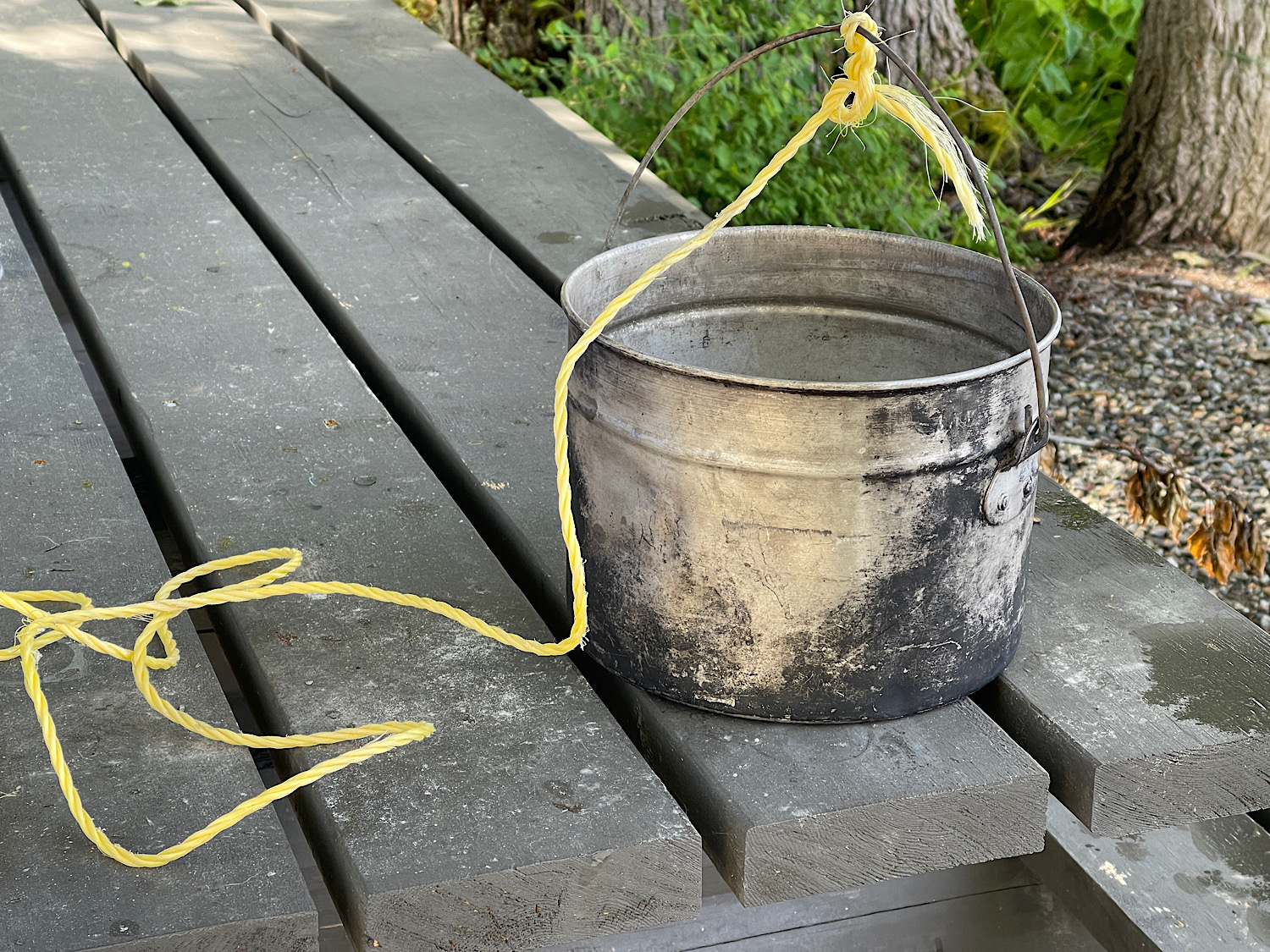 A camping pot with a rope tied to the handle